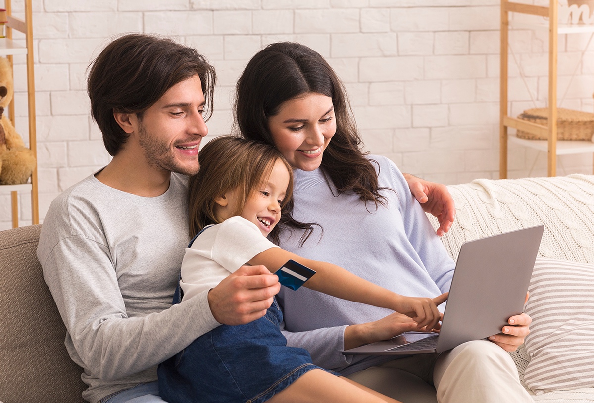 young family online shopping together on sofa