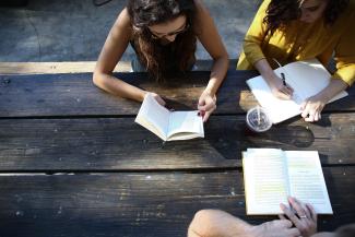 woman reading book while sitting on chair by Alexis Brown courtesy of Unsplash.